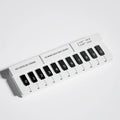 Black and white plastic piano-shaped temporary parking sign for car dashboard.