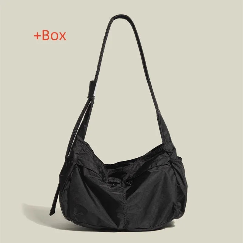 Large black nylon waterproof messenger bag with a single shoulder strap, shown open to reveal internal organisation.