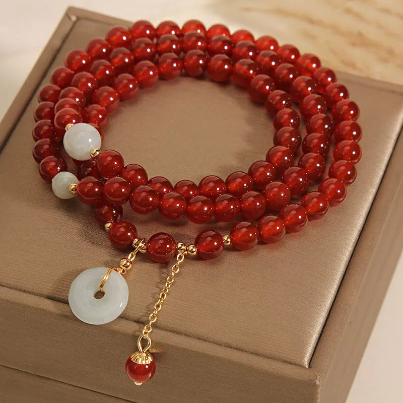 Women's multi-layer bracelet with red agate stones and crystal embellishments on adjustable band