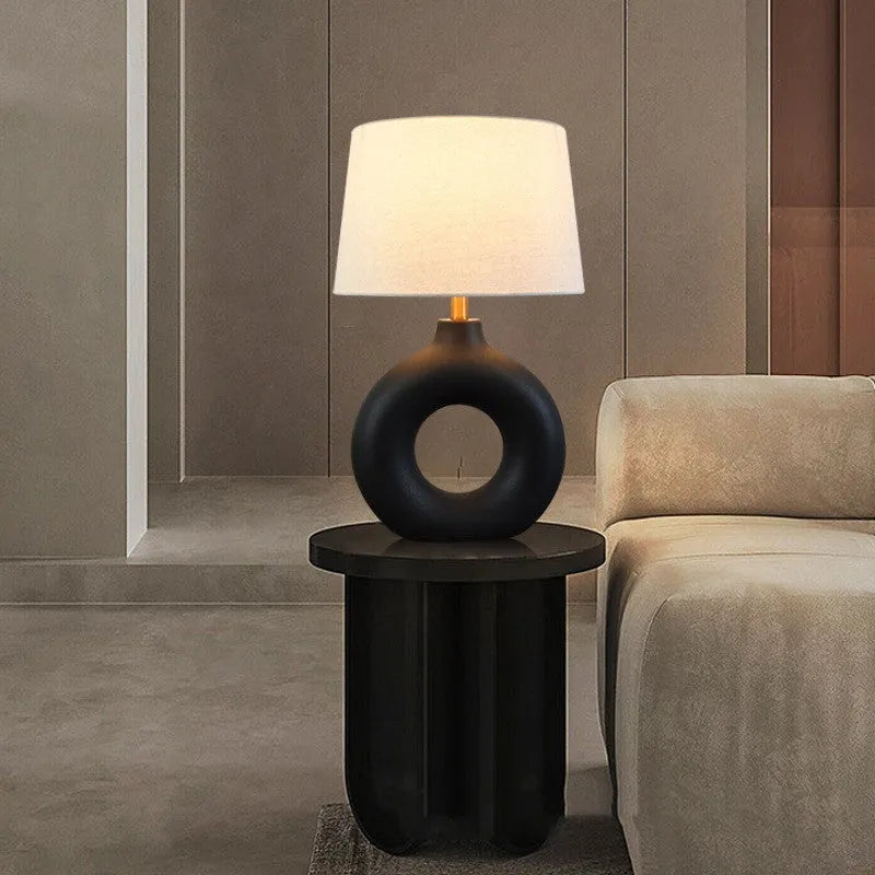 Small white Feng pottery Japanese-style table lamp with button switch on a desk.