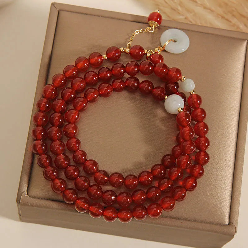 Women's multi-layer bracelet with red agate stones and crystal embellishments on adjustable band