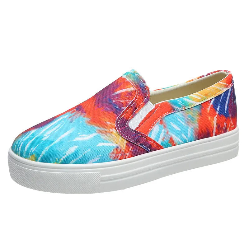 Women's low-top canvas trainers in blue, green, black and colourful patterns with a flat rubber sole.