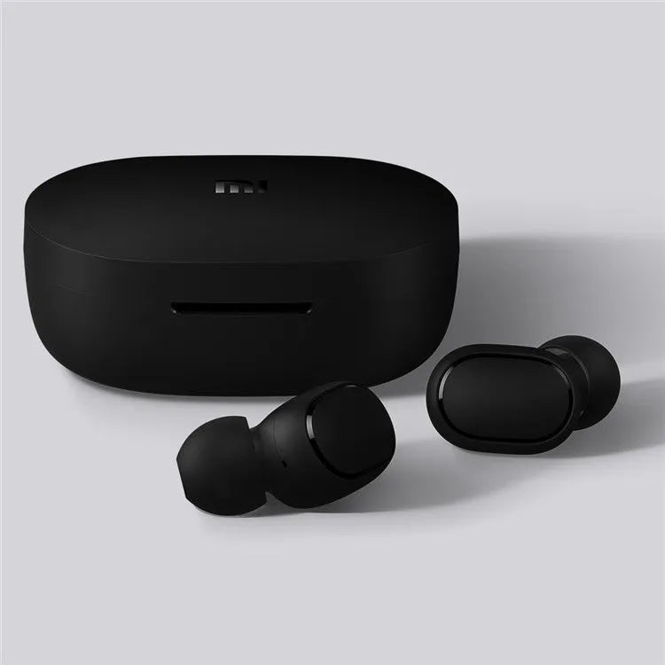Redmi AirDots black true wireless earbuds and charging case on a table.