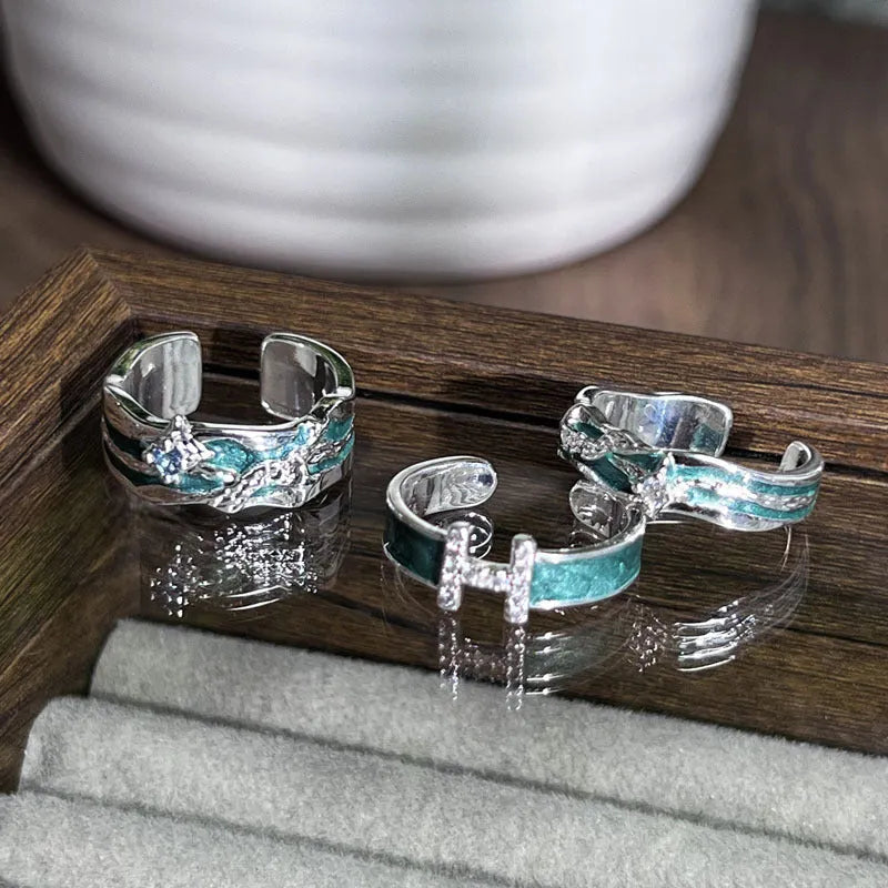 Mint green enamel asterism ring with copper folding geometric design on a hand.