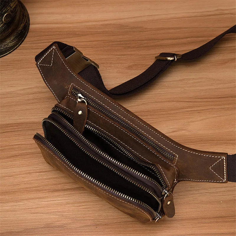 Brown cowhide leather men's waist bag with pull closure, shown with internal mobile phone compartment.