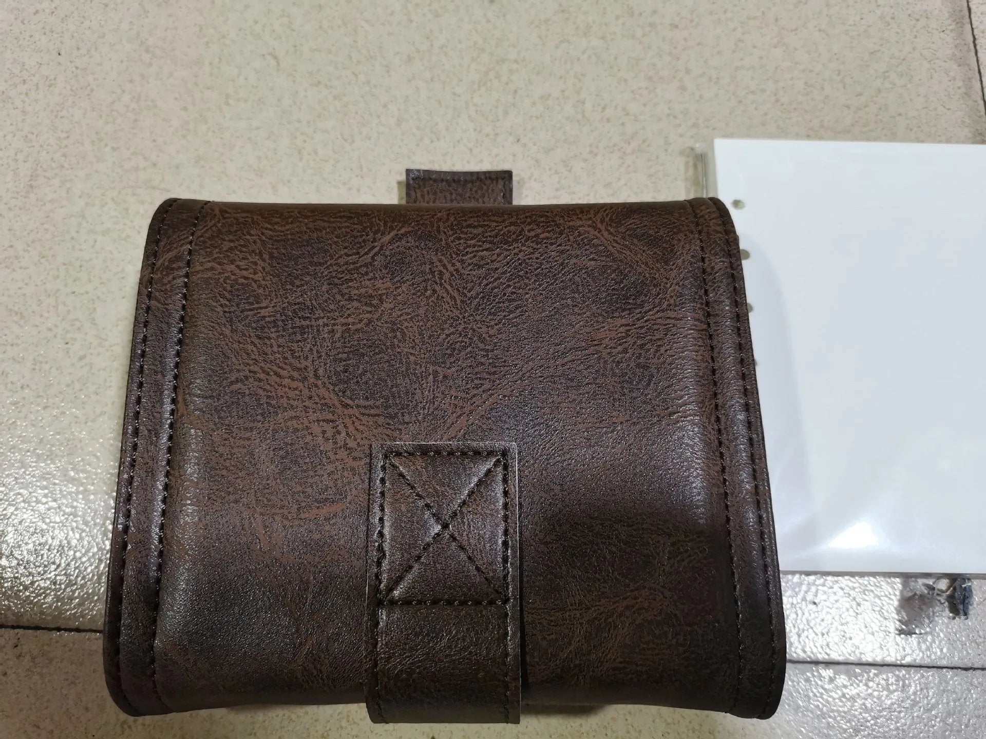 Brown retro-style notebook with a buckle closure and loose-leaf binder binding