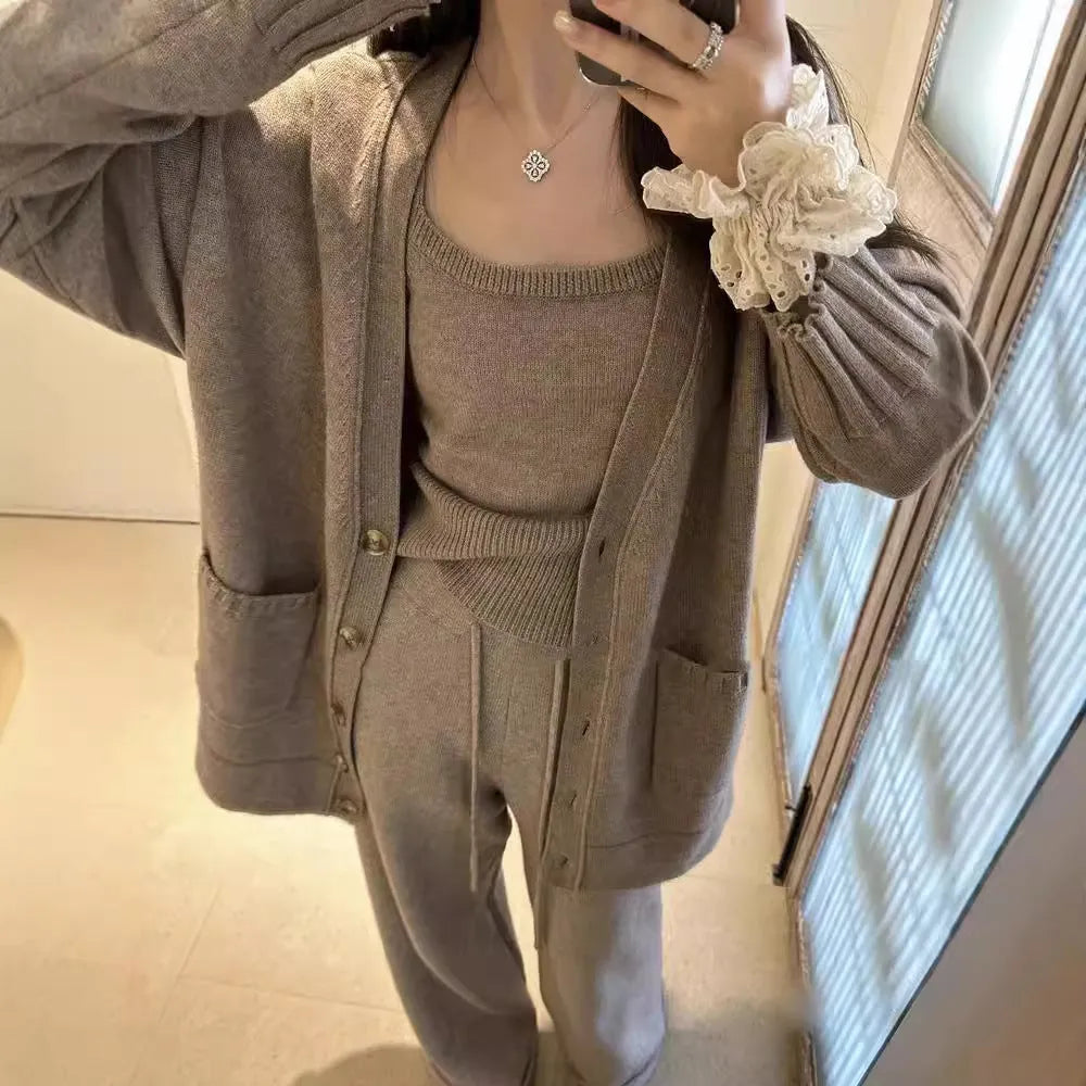 Women's light brown knit cardigan vest and trousers three-piece set laid flat.