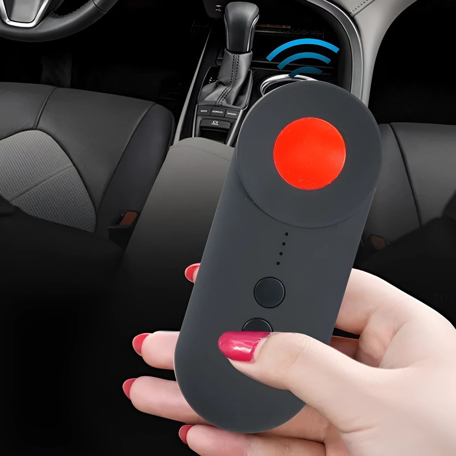 Black portable GPS and hidden camera detector with USB charging cable on a grey background.