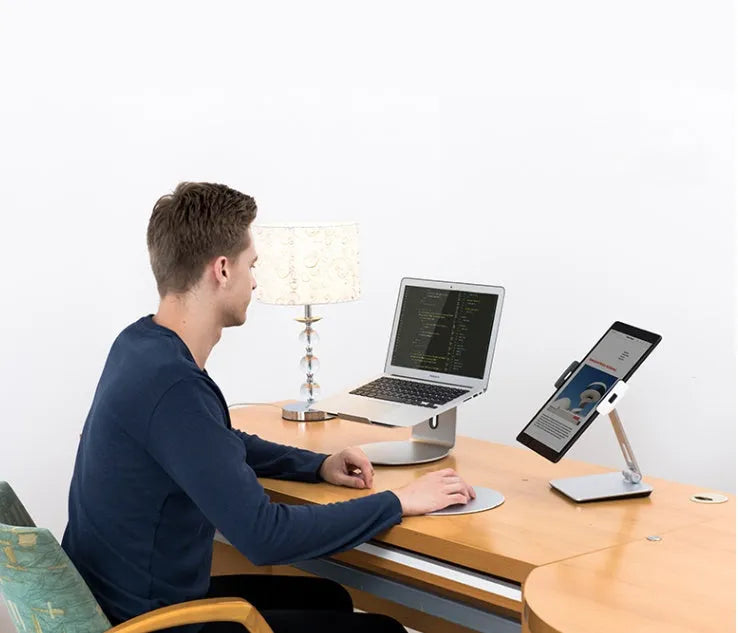 Folding aluminium phone and tablet stand in silver, shown holding a tablet at an angle.