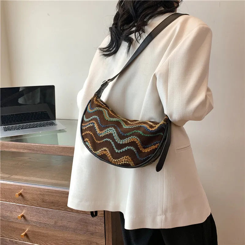 Women's woven straw crossbody bag showing internal phone pocket and file compartment in corrugated black colour