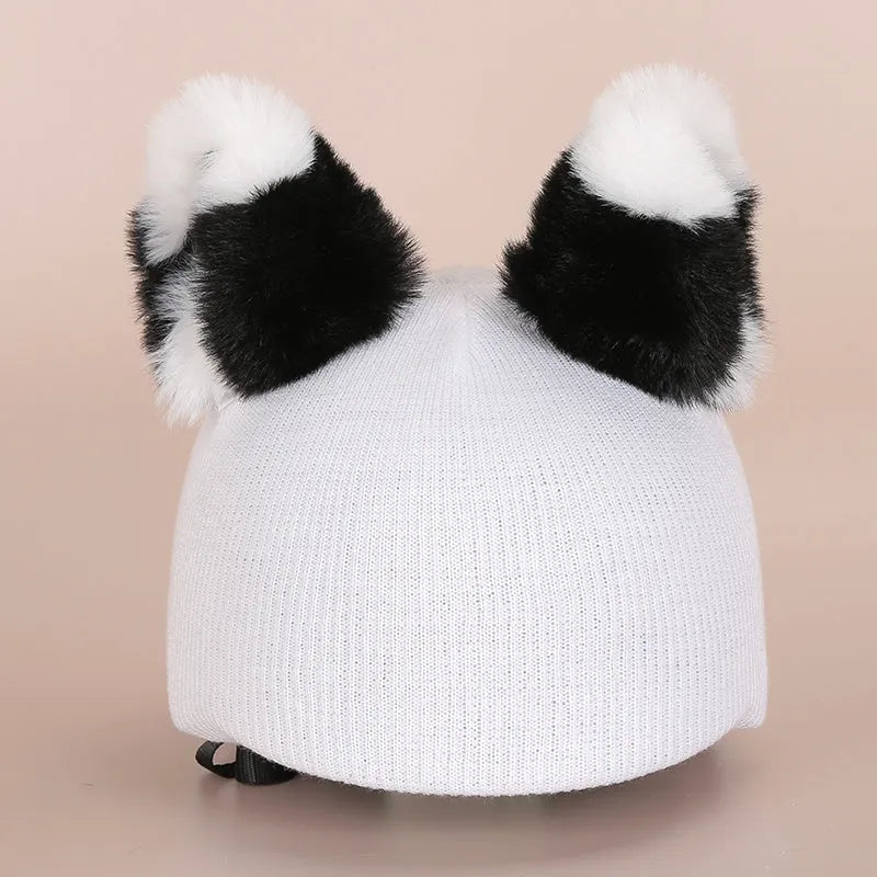 Soft plush cartoon helmet decoration sitting on top of a black ski boot.