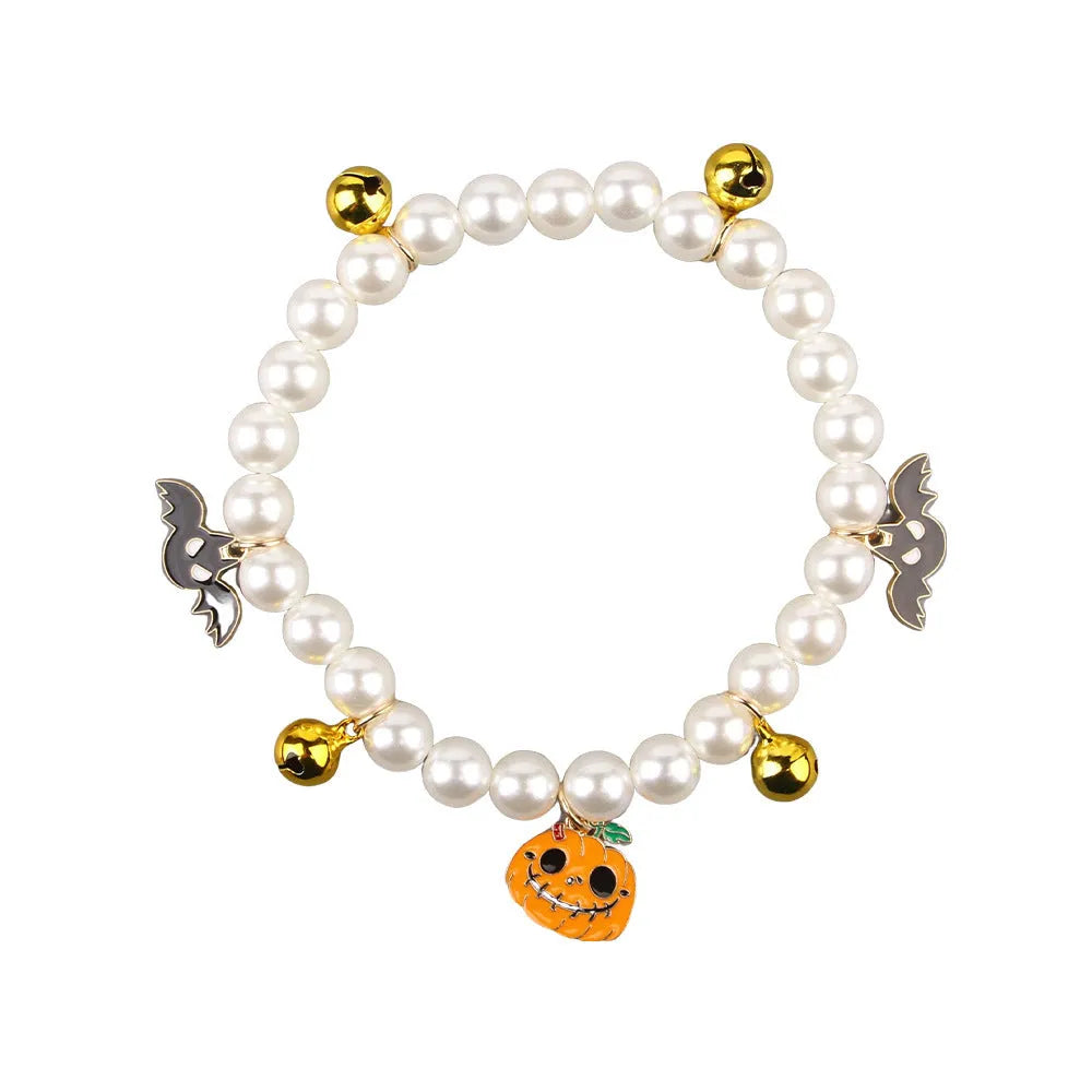 Simulated pearl Halloween cat collar with a choice of purple ghost, skull, or smiling pumpkin charm.