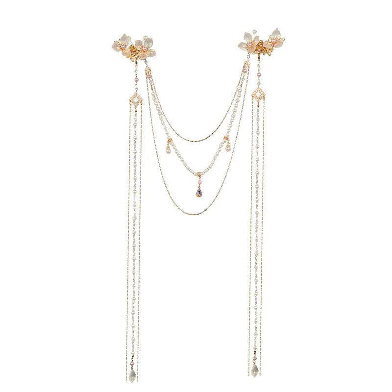 Gold acrylic women's hairpin with white flower, pearl beads, diamond accents, and a long black tassel.