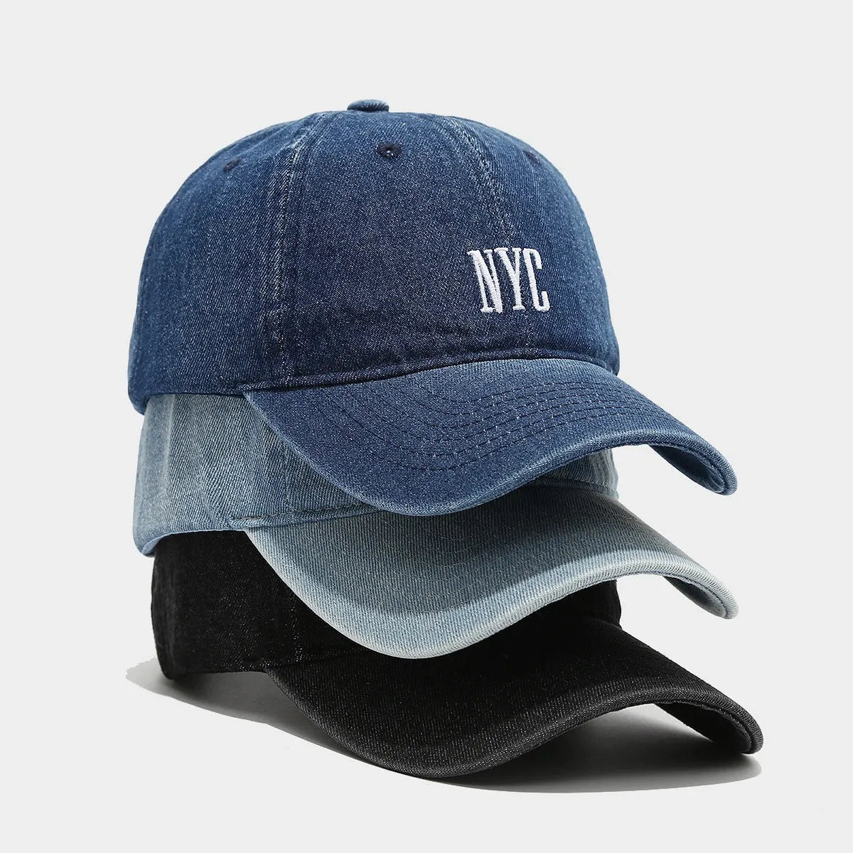 Light blue denim peaked cap with embroidered lettering on the front, showing adjustable strap.