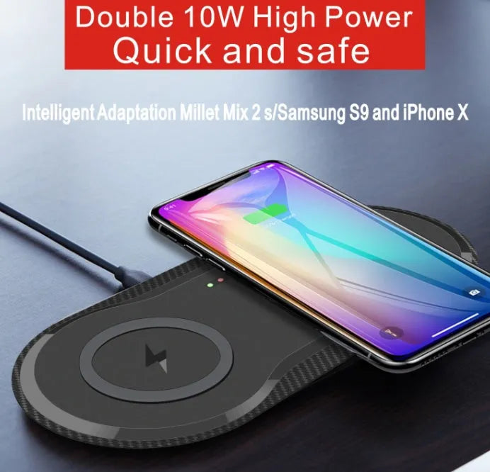 Black dual wireless charging pad showing two smartphones charging simultaneously on a desk.