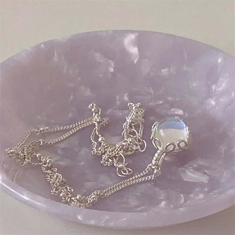 Silver necklace with geometric stone pendant on an adjustable curb chain.