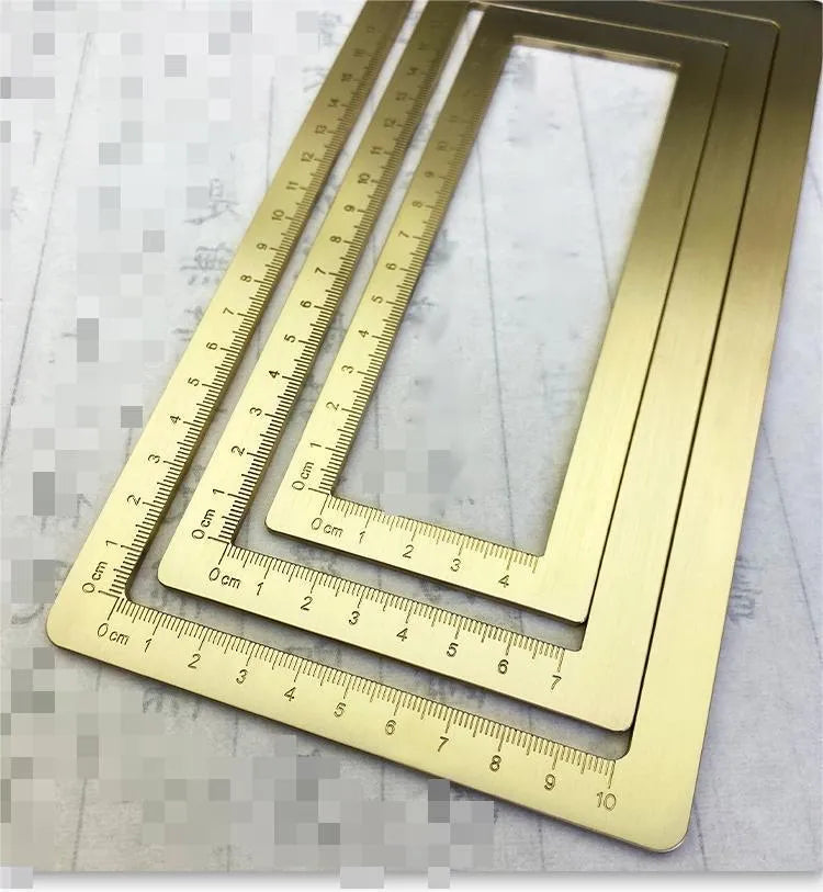 Solid brass calligraphy paper weight with engraved design on a wooden desk.