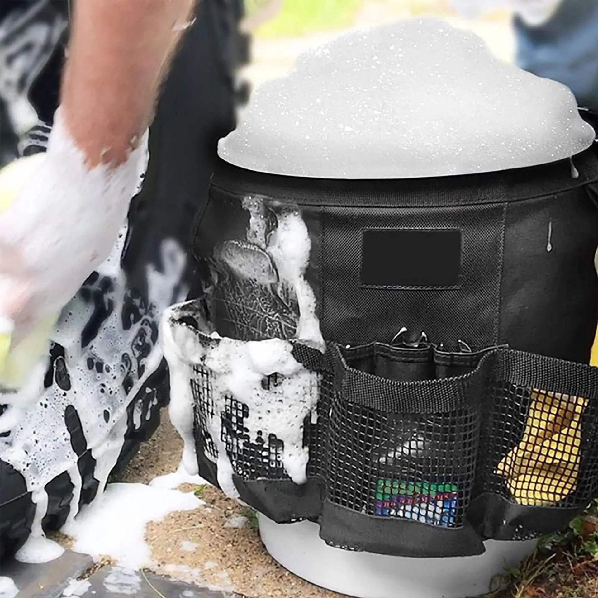 Black cylindrical polyester storage bag hanging on a 5 gallon barrel for organising tools.