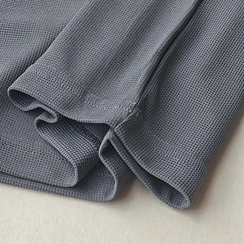 Men's dark grey waffle-knit short sleeve T-shirt showing textured fabric detail.
