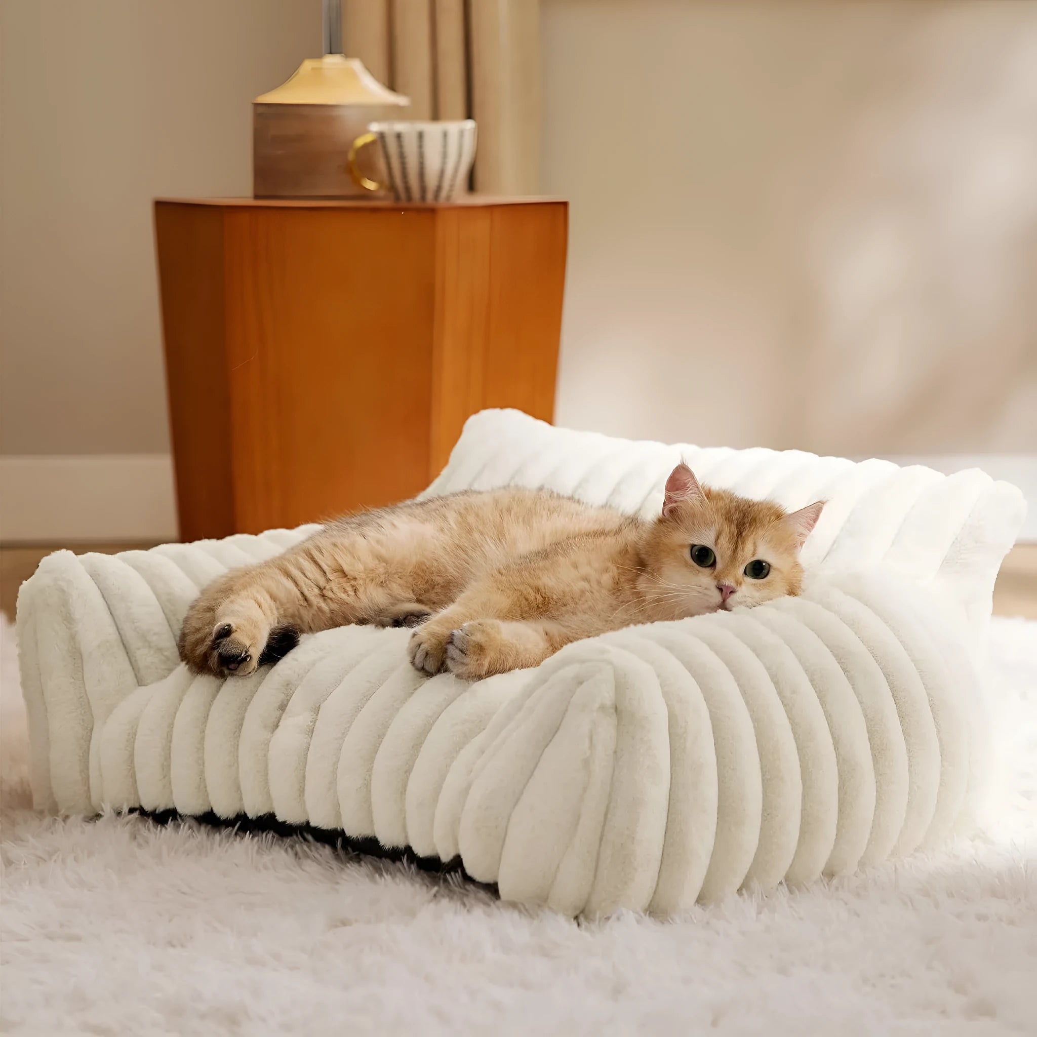 Beige corduroy fleece pet couch with high backrest and sides on a wooden floor.