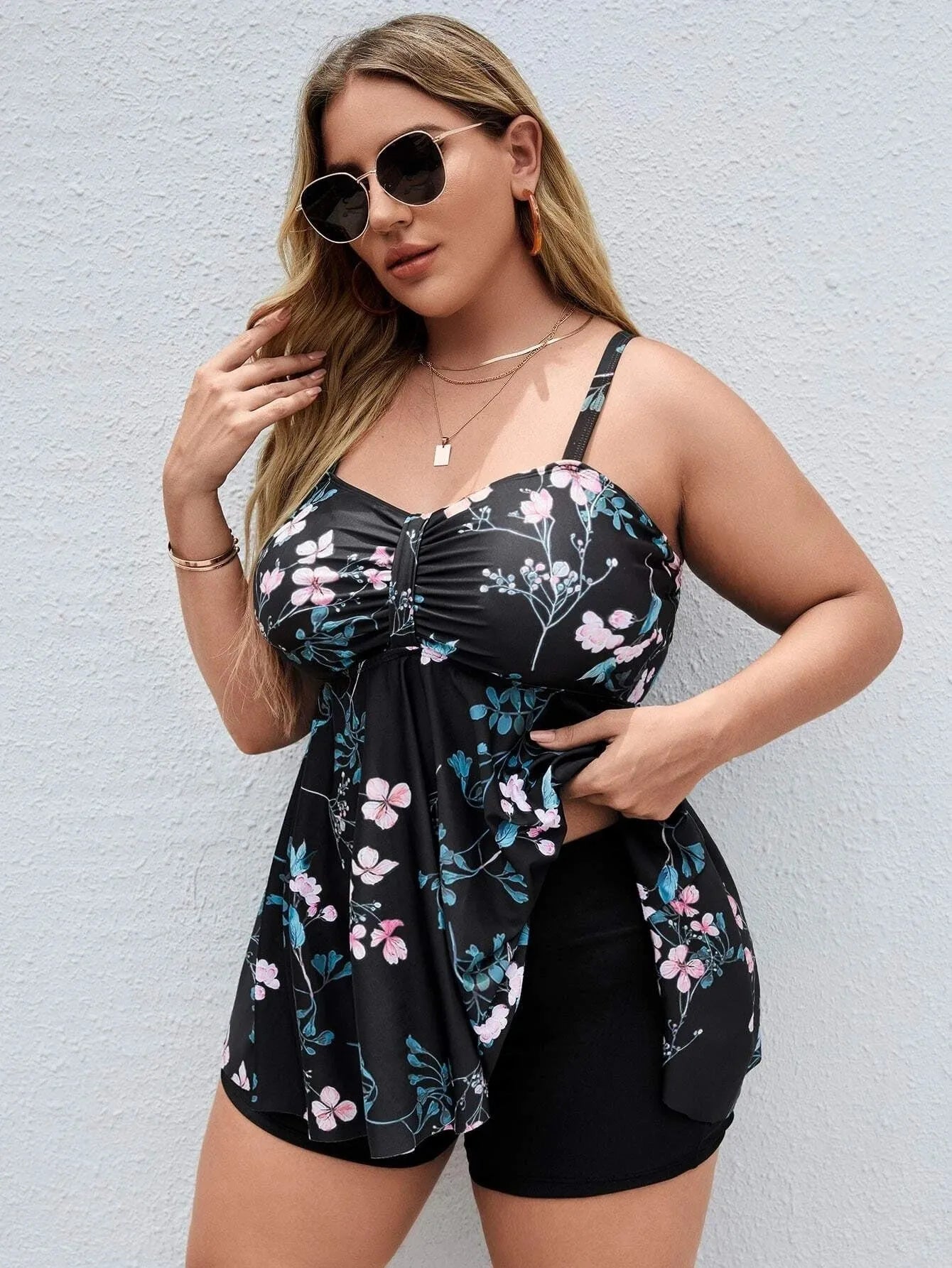 Women's floral print one-piece swimsuit with split colour design, shown on a hanger.