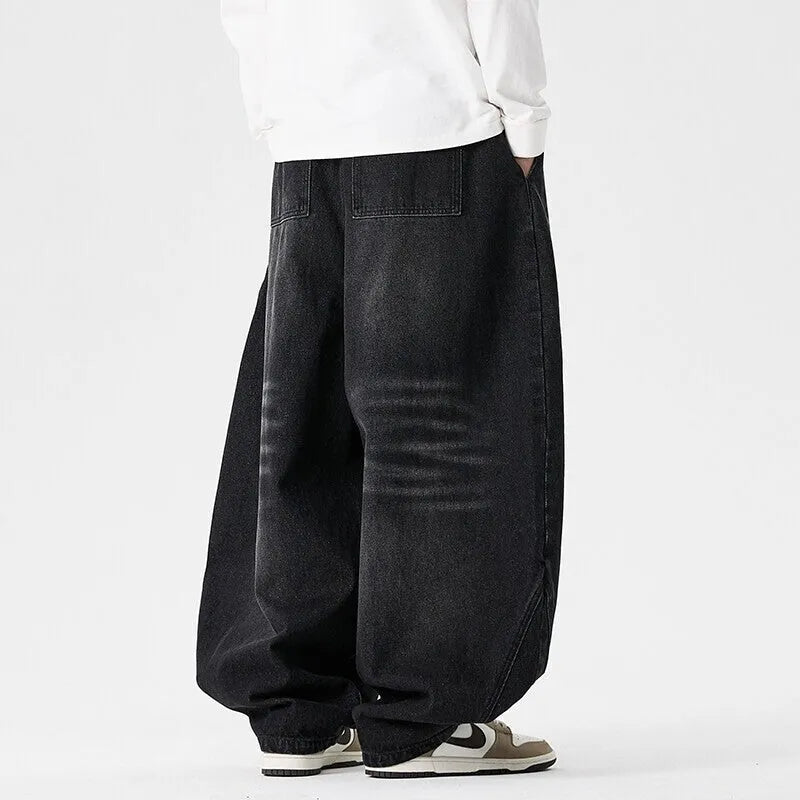 Men's plus size light blue baggy wide-leg jeans on a hanger, showing straight leg and low waist.