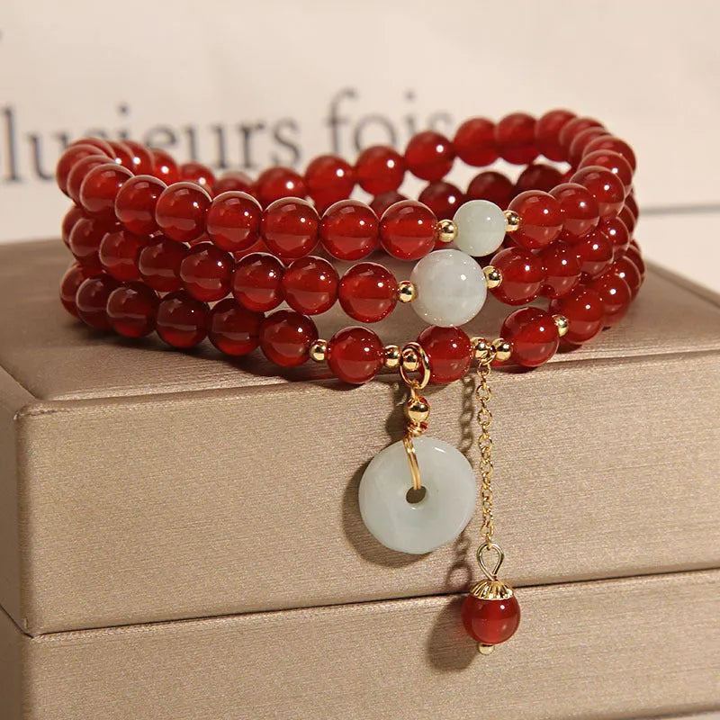 Women's multi-layer bracelet with red agate stones and crystal embellishments on adjustable band