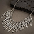 Silver alloy skull and ghost claw necklace with matching earrings set on a dark background.
