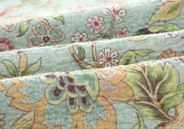 Blue American style floral bird quilted cotton bedspread set on a bed