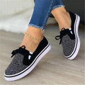 White women's lace-up canvas flat shoes with cross straps and round toe on a plain background