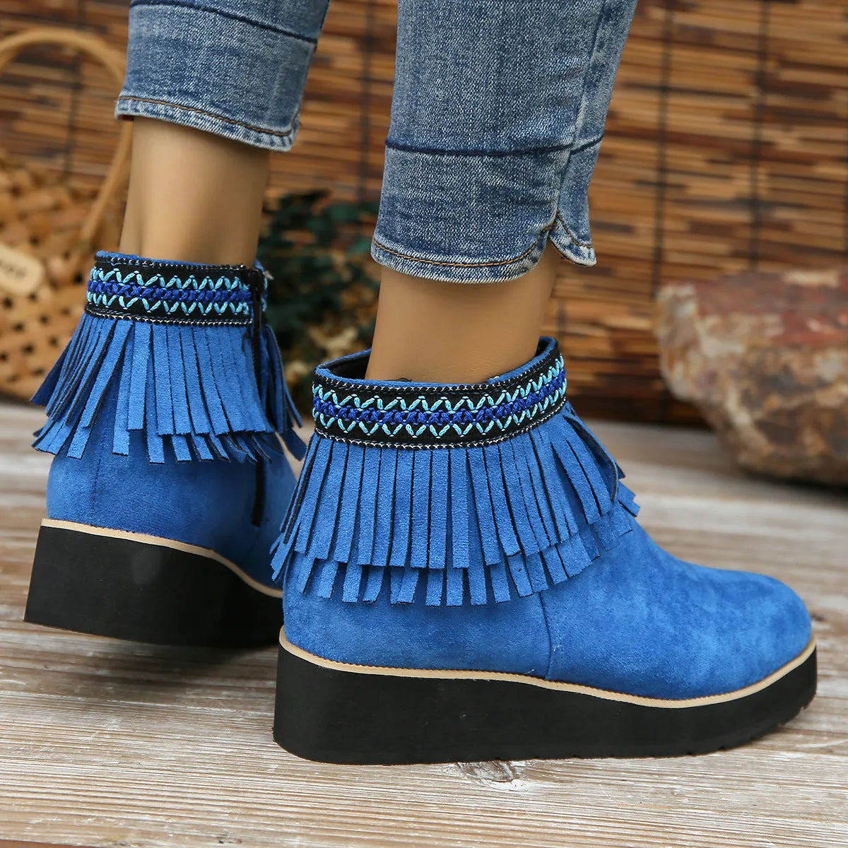 Women's dark brown suede ankle boots with wedge heel, platform sole, side zip, and tassel detail.