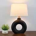 Small white Feng pottery Japanese-style table lamp with button switch on a desk.