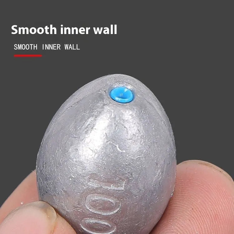 Tongxin olive lead fishing sinker with scale pattern and plastic core in rugby shape.