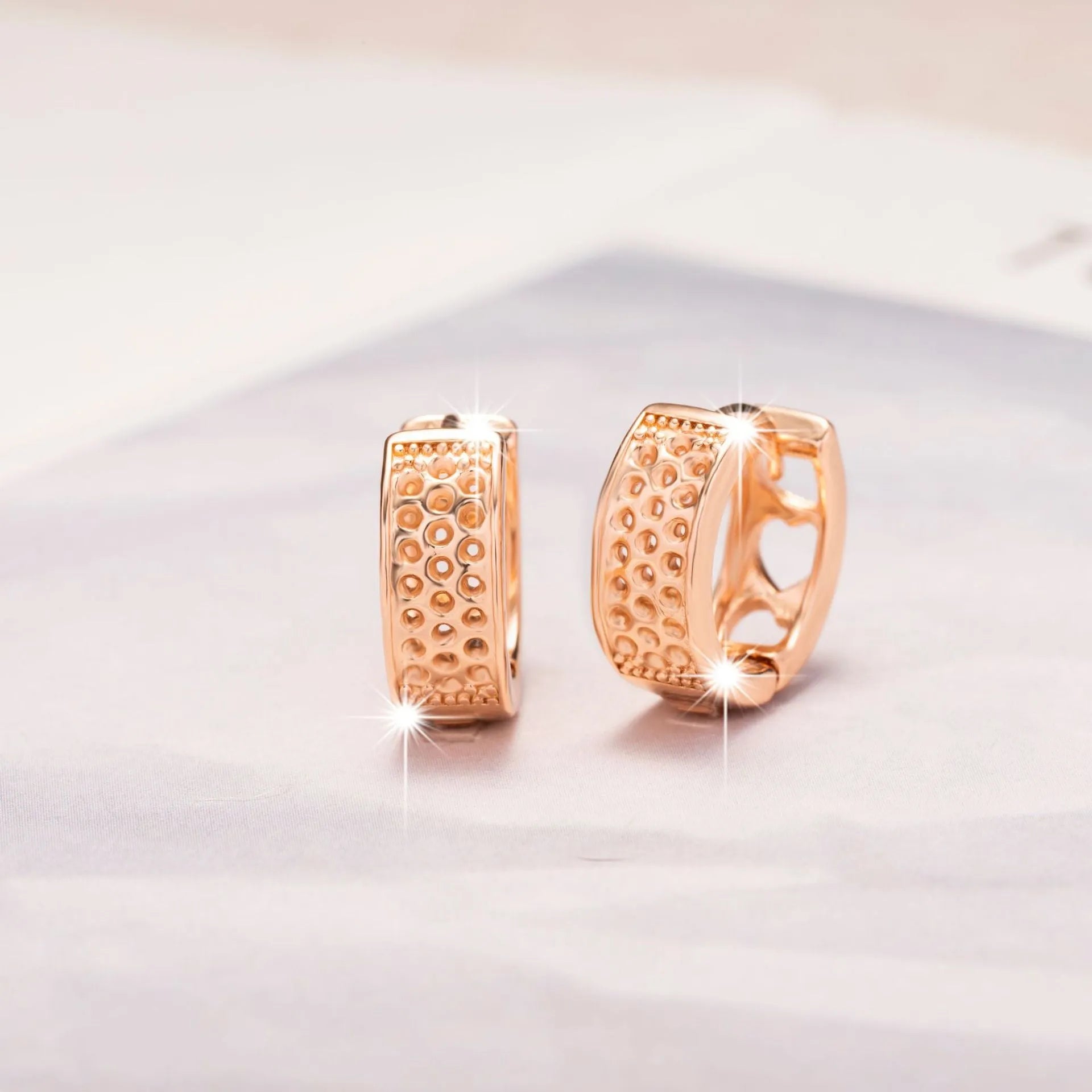 Rose gold women's earrings with three hollowed-out heart shapes in circular pattern
