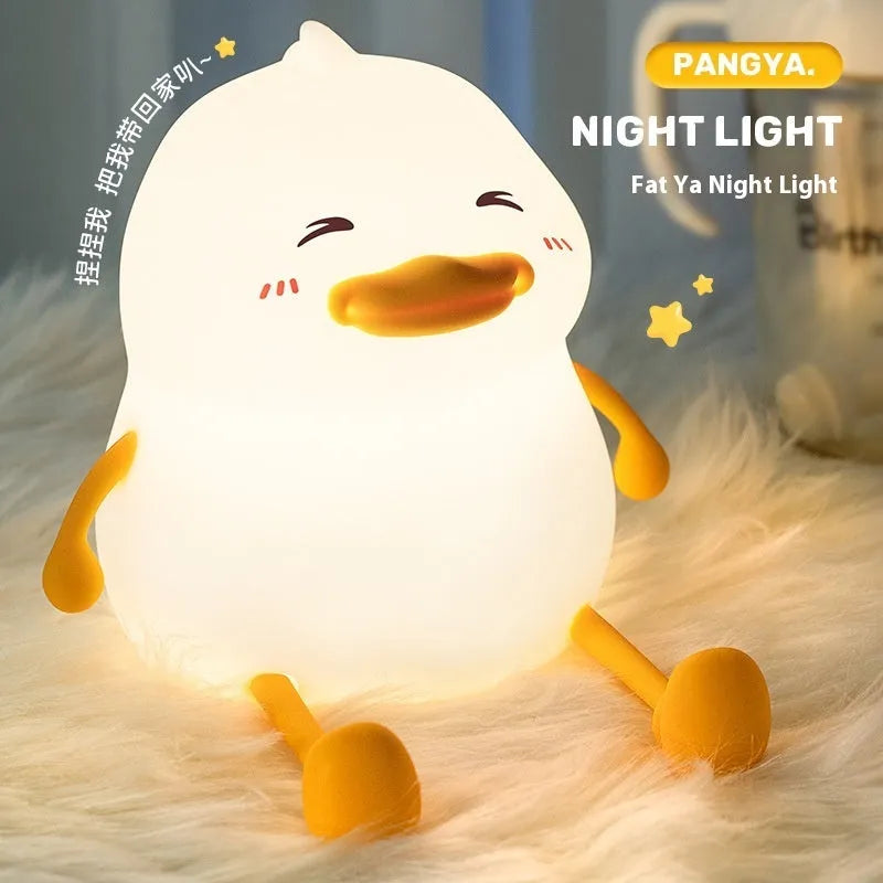 Chubby silicone desk night lamp with integrated mobile phone holder showing soft glowing light.