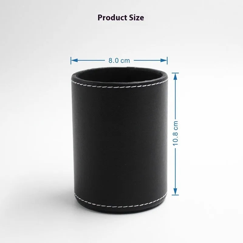 Round black leather pen container on desk holding writing instruments