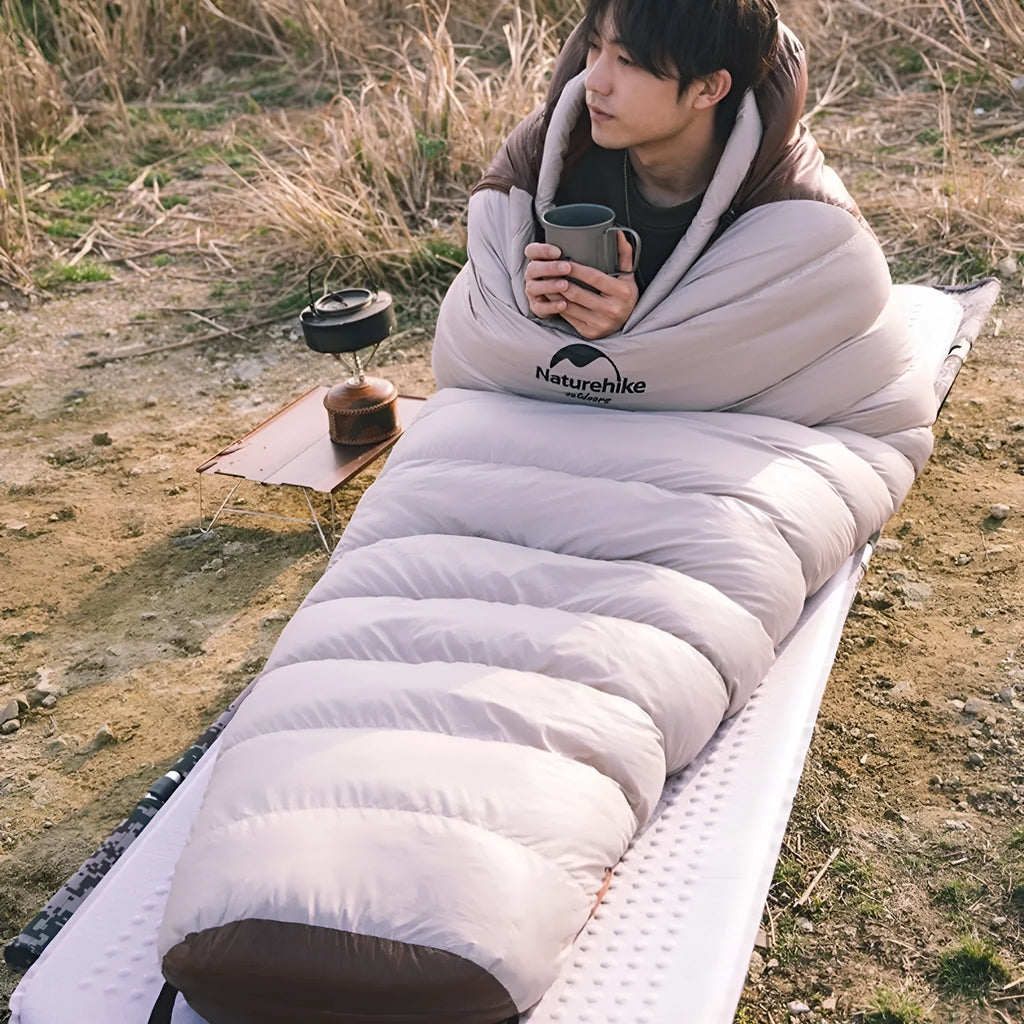 Goose down mummy sleeping bag for adults with storage sack, showing various weight options.