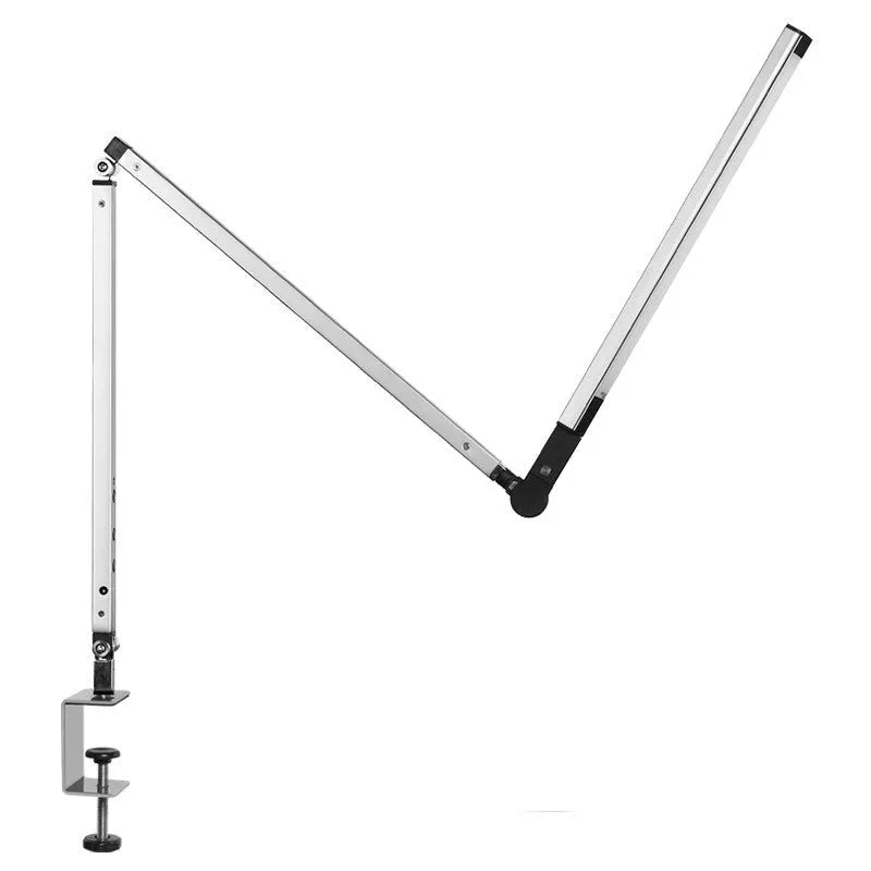 Aluminium clip-on desk lamp with adjustable arm and remote control on a wooden desk.