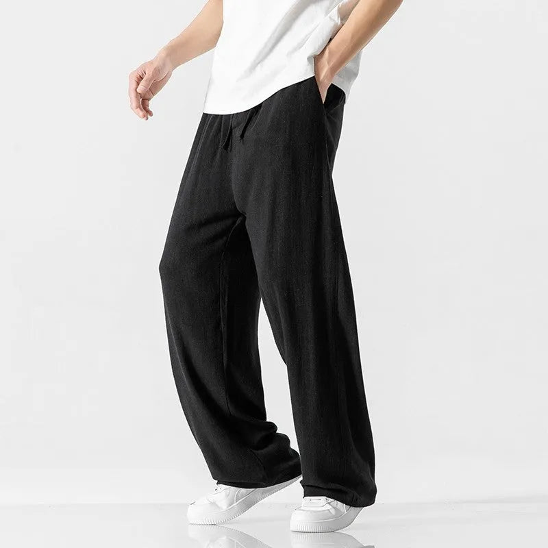 Men's beige cropped linen trousers with a drawstring waist and straight-leg casual style on a hanger.