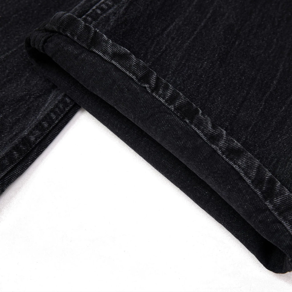 Black men's straight-leg jeans showing a cracked, washed denim finish on a plain background.