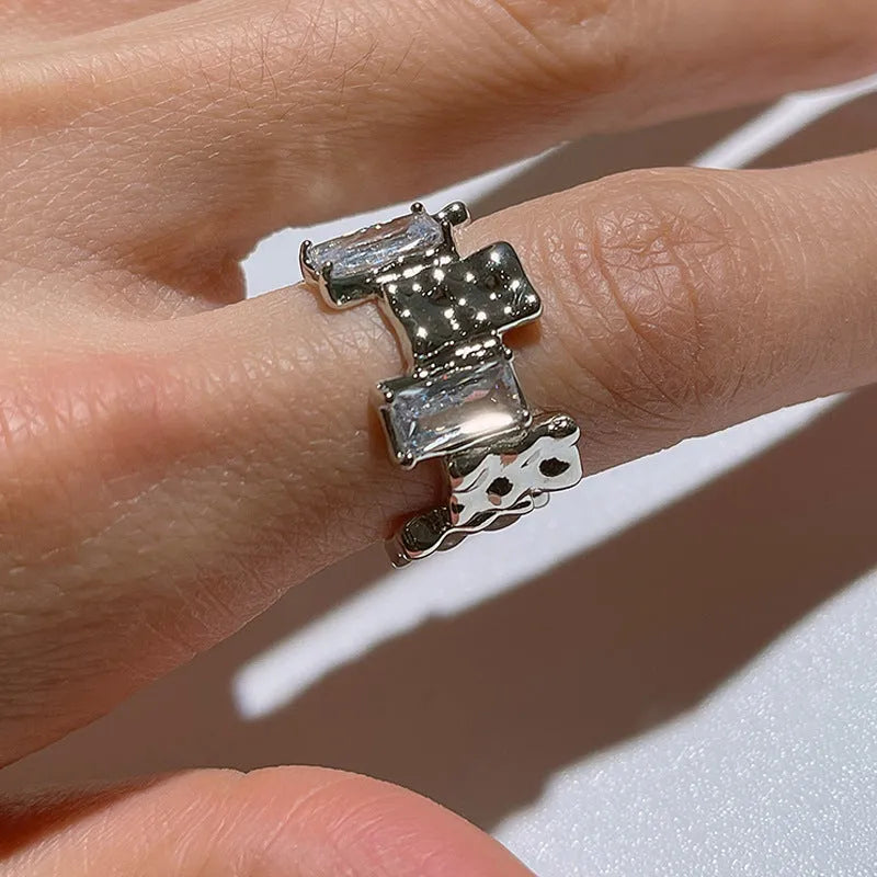 Silver geometric open ring with cross design and zircon centrepiece
