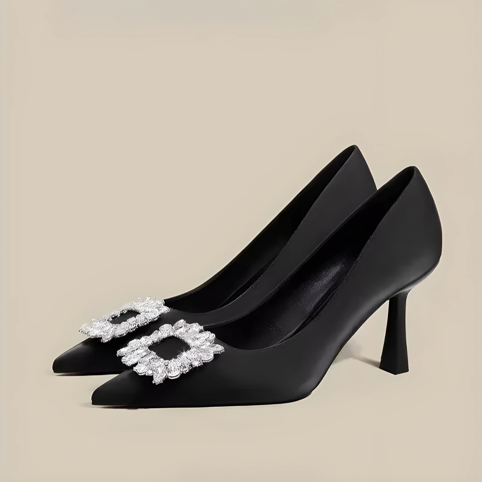 Creamy-white or black women's pointed toe high heels with a stiletto heel on a plain background.