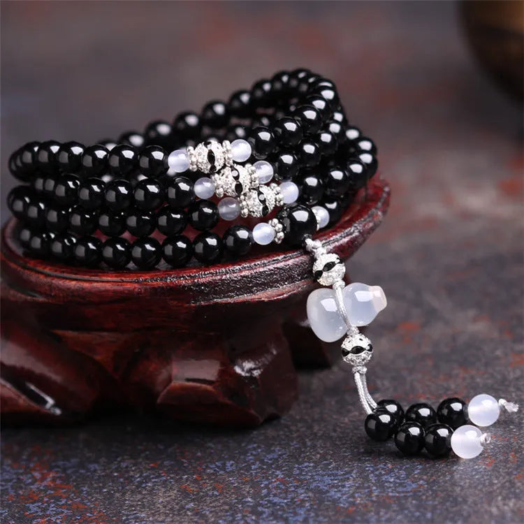 Black agate geometric bead bracelet with 108 beads and number details on a wrist.