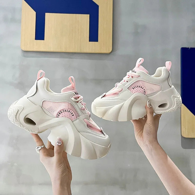Women's pink sneakers with thick soles, cross shoulder straps, and a breathable mesh lining on a white background.