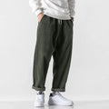 Men's loose straight-leg corduroy sports trousers in army green, laid flat to show fit and texture.