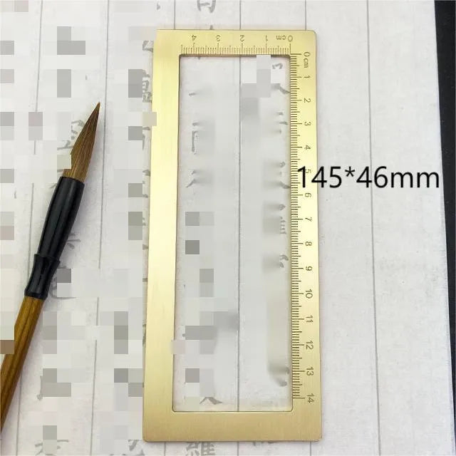 Solid brass calligraphy paper weight with engraved design on a wooden desk.