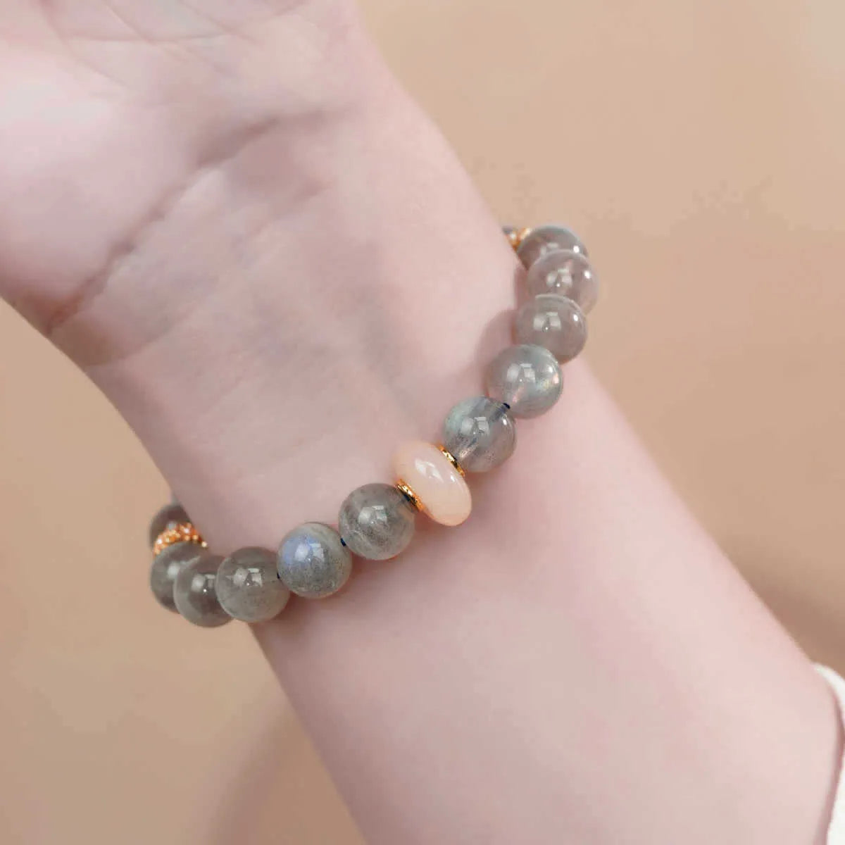 Gray moonstone agate women's half bracelet with 8mm round beads on a wrist.