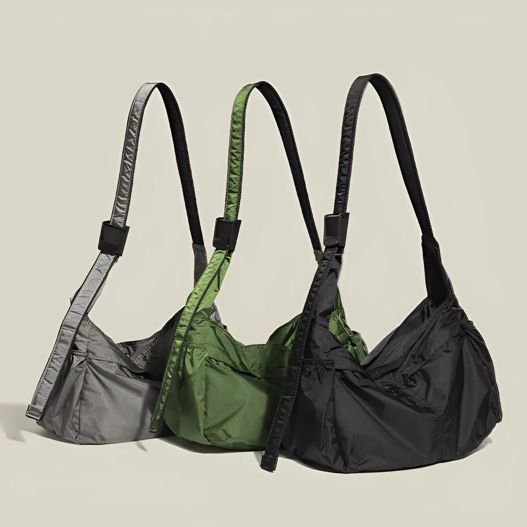Large black nylon waterproof messenger bag with a single shoulder strap, shown open to reveal internal organisation.