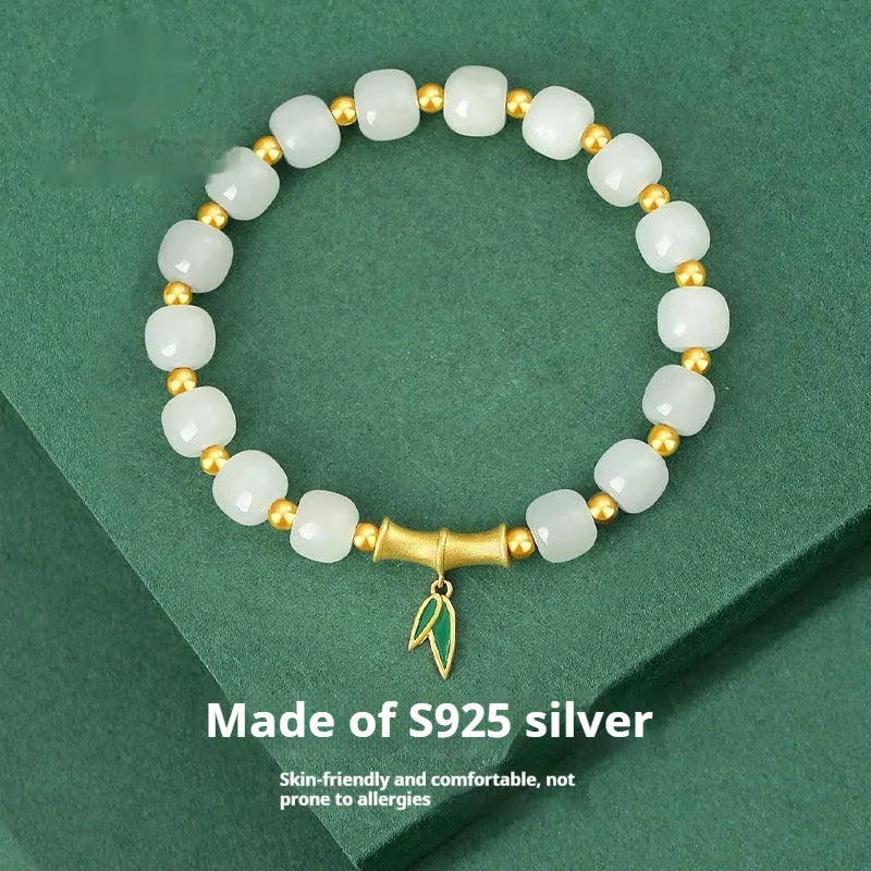 Natural Hetian jade and sterling silver bamboo leaf bracelet on a wrist, showing gold and silver finish options.