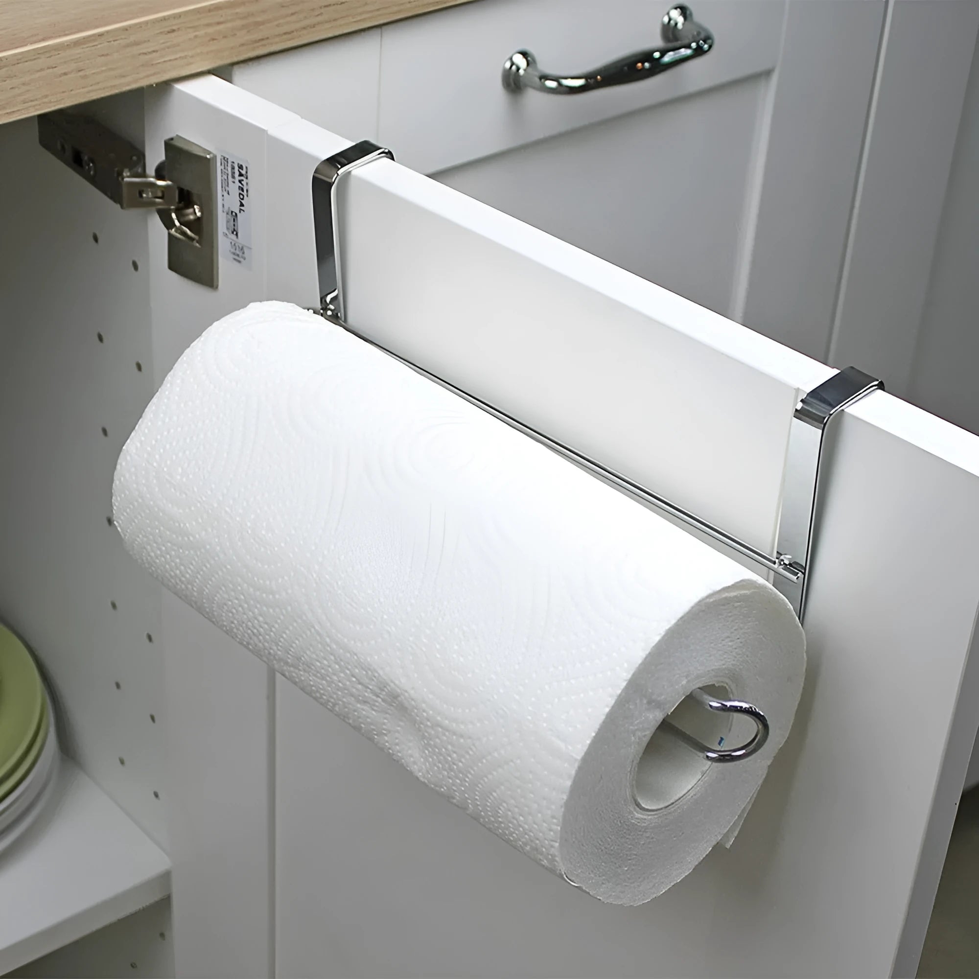 Silver stainless steel kitchen towel rack hanging on a cabinet door.